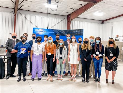 group photo of students with CEO mentors on the trade show floor